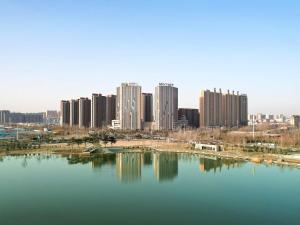 een stad met hoge gebouwen en een grote hoeveelheid water bij Mercure Anyang Downtown in Anyang