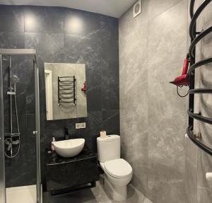 a bathroom with a toilet and a sink and a mirror at Апартаменти Промінь ЖК яровиця Луцьк in Luts'k +32 photos
