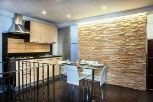 a kitchen with a glass table and white chairs at Hotel Diffuso Antichi Ricordi in Caltanissetta