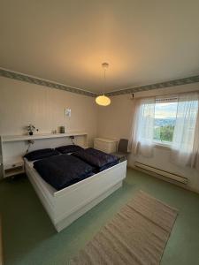 a bedroom with a bed and a window and a rug at Tromsø pearl near mountains, city life and northern lights in Tromsø