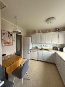a kitchen with white cabinets and a wooden table at Tromsø pearl near mountains, city life and northern lights in Tromsø