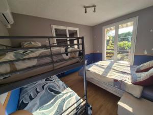 two bunk beds in a room with a window at Chambre bleu dans un appartement independant de l habitation in Nouzilly