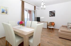 a dining room and living room with a table and chairs at Vista Apartments in Cavtat