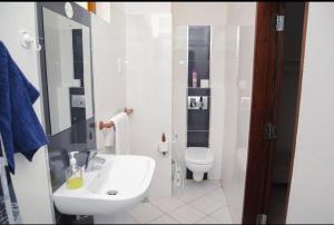 a white bathroom with a sink and a toilet at Aruba Home in Kwale +17 photos
