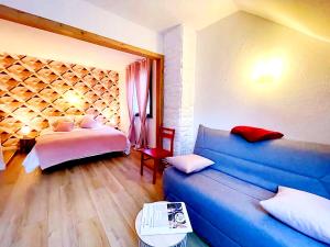 a living room with a blue couch and a bed at Domaine de la Papeterie in Glay