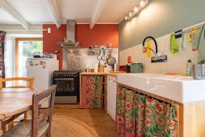 a kitchen with a sink and a refrigerator and a table at La Casita in Beauvène +12 photos