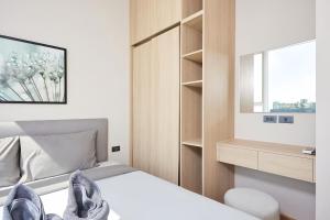 a small bedroom with a bed and a mirror at Wyndham Garden Residence Sukhumvit 42 in Bangkok