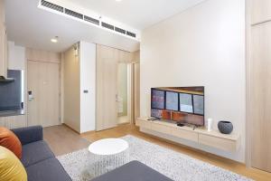 a living room with a couch and a tv at Wyndham Garden Residence Sukhumvit 42 in Bangkok