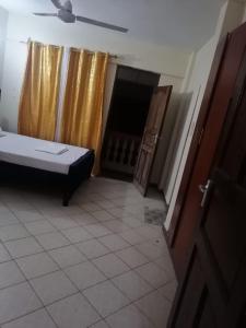 a room with a bed and a door and a room with a fireplace at La Grande Cosy 1 Bedroom Ensuite Mtwapa in Mtwapa