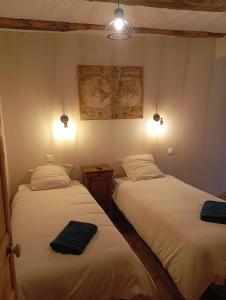 two beds in a room with lights on the wall at Gîte Le Mansois in Marcillac-Vallon +5 photos