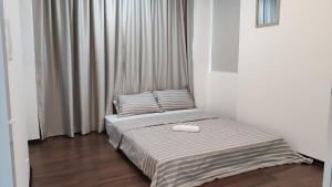 ein Schlafzimmer mit einem Bett mit einer weißen Decke in der Unterkunft Leisure Homestay BM in Bukit Mertajam