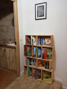 a book shelf filled with books next to a wall at Gîte Le Mansois in Marcillac-Vallon