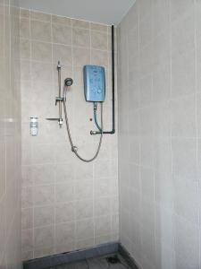eine Dusche im Bad mit einem blauen Telefon an der Wand in der Unterkunft Leisure Homestay BM in Bukit Mertajam