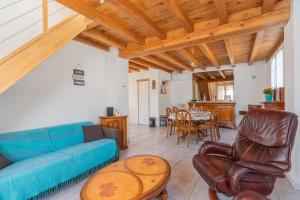 a living room with a blue couch and a table at Lumineux appart à 300m de la plage in La Tremblade