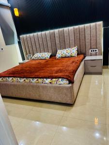 a large bed with a large headboard in a room at A5 tower flat number 708 in Karnal