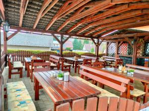 an empty restaurant with wooden tables and benches at Penzion a restaurace Polnička in Polnička
