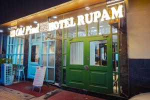 a green front door of a restaurant with a sign at Rupam Hotel - Air Purified comfort in New Delhi