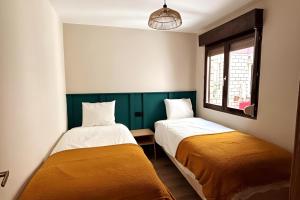 two beds in a room with green and white at Catedral Suite - Vistas a la Catedral & Parking in León