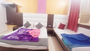 two beds in a room with a purple blanket at Hotel M India Dx- NEAR NEW DELHI RAILWAY STATION in New Delhi