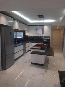 a large kitchen with white cabinets and a counter top at Oa Ceșme Villa in Cesme