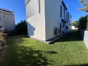 a yard with green grass next to a white building at Oa Ceșme Villa in Cesme