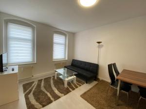 ゲーラにあるBüchner 50の黒いソファとテーブルのあるリビングルーム