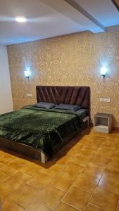ウーティにあるgreen mountain homestayのベッドルーム1室(ベッド1台、緑の掛け布団付)