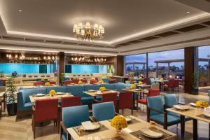 a rendering of a restaurant with tables and chairs at Sarovar Portico Hanumangarh in Hanumāngarh