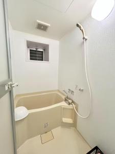 a white bathroom with a sink and a shower at 女性専用ゲストハウス与那原 in Yonabaru +18 photos