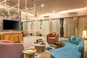 a living room with couches and a flat screen tv at Raina Villas Goa 6 bhk lux Pvt Pool in Arpora