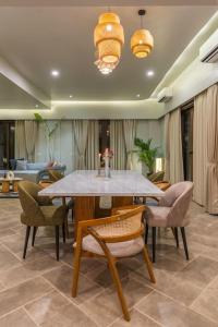 a dining room with a table and chairs at Raina Villas Goa 6 bhk lux Pvt Pool in Arpora