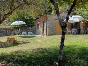 ein Steinhaus mit Sonnenschirm und Hof in der Unterkunft Casetta Girasole - Monterchi in Monterchi