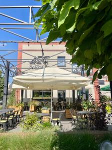 a patio with tables and chairs under an umbrella at ART Pensjonat in Krotoszyn