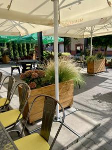 an outdoor patio with chairs and tables and an umbrella at ART Pensjonat in Krotoszyn +28 photos