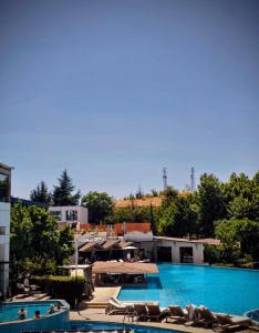 a large swimming pool with chairs and a resort at Apartment - Studio Cucetno in Sandanski