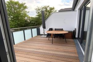 a balcony with a wooden table on a building at Exclusives Appartement auf Fehmarn in Petersdorf auf Fehmarn