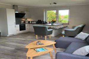 a living room with a couch and a table at Exclusives Appartement auf Fehmarn in Petersdorf auf Fehmarn