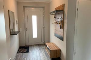 a hallway with a wooden bench and a door at Exclusives Appartement auf Fehmarn in Petersdorf auf Fehmarn +68 photos
