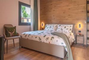 a bedroom with a bed and a chair and a window at Camping Village Ekar Asiago in Asiago