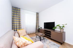 a living room with a couch and a tv at Turistická ubytovňa pri Spojenom školskom internáte Werferova 10 in Košice