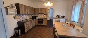 a kitchen with a wooden table and a table and chairs at Chata Pohoda Abertamy - Finská sauna in Abertamy