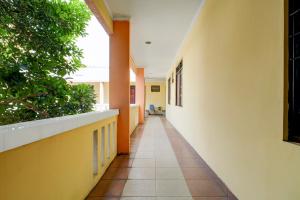 Un pasillo vacío en un edificio escolar con plantas. en OYO 94632 Griya Cewang Syariah, en Bekasi