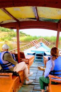 a man and a woman sitting on a boat at Twin Lakes Rwanda Boat Tours in Ruhondo