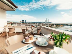 a restaurant with tables and chairs on a balcony with a view at Martin's Guesthouse in Basel