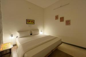 Un dormitorio con una gran cama blanca en una habitación. en Pushkar Story Homestay, en Pushkar