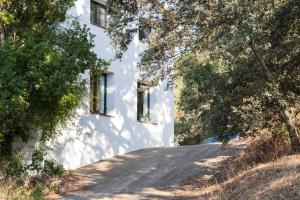 a white house with two windows on a road at Casa Correcaminos in La Presa