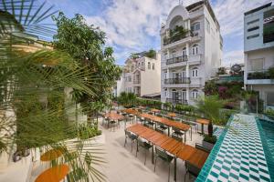 a hotel patio with tables and a swimming pool at The Amber Flame Saigon-Modern Hideout with Rooftop Pool & Bar Access-Near Bùi Viện in Ho Chi Minh City
