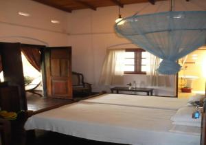 a bedroom with a large bed and a window at Olde Empire Hotel in Kandy