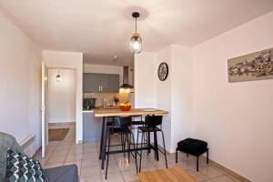 Una cocina y una sala de estar con mesa y sillas. en Casa San Roccu, en Saint-Florent