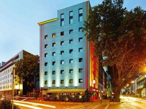 ein hohes Gebäude in einer Stadtstraße bei Nacht in der Unterkunft 25hours Hotel The Goldman in Frankfurt am Main